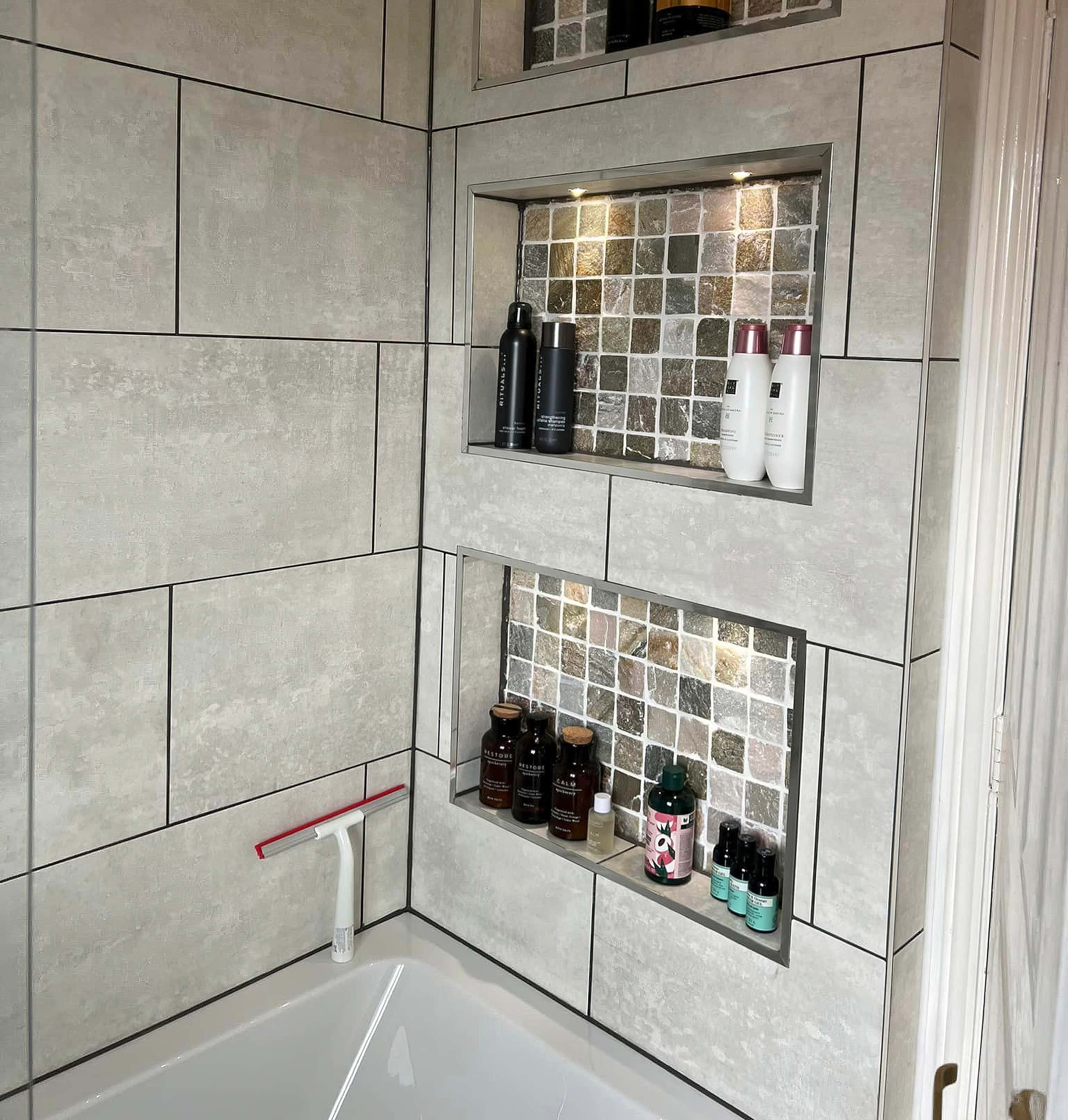 Luxury bathroom display shelving with spotlights and tiled back crafted by Plumb Yorkshire Ltd.