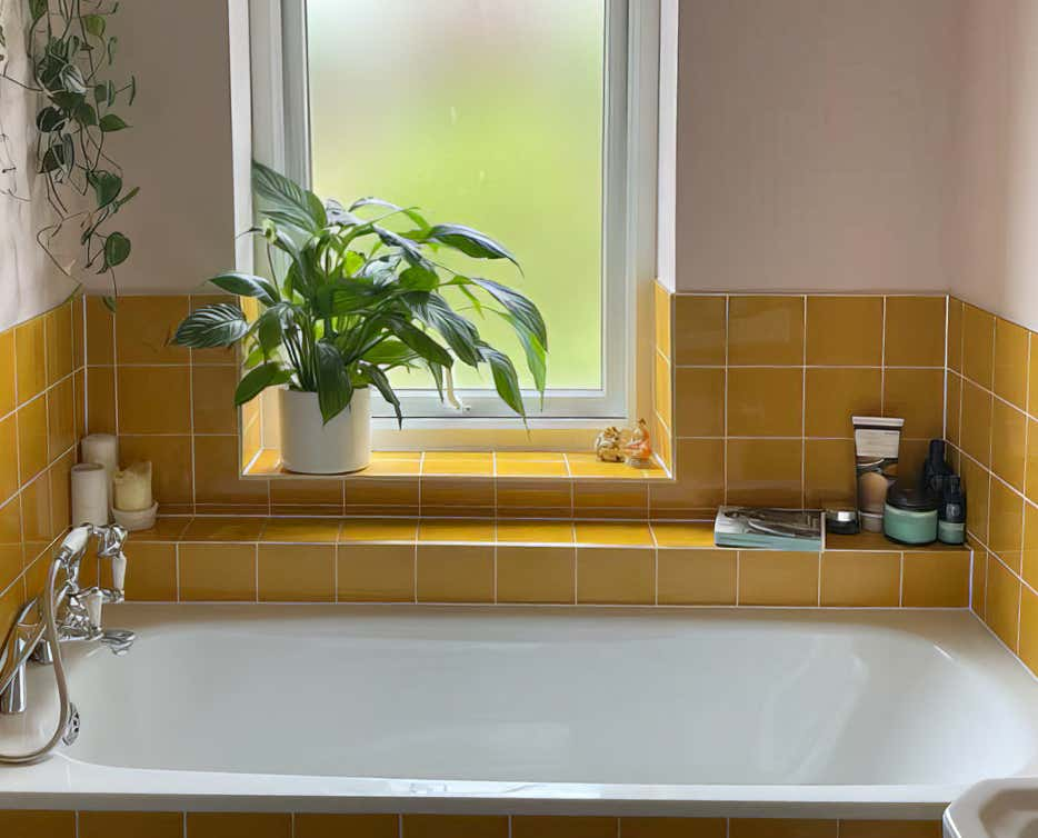 Image of a bath in a stylish mustard tiled bathroom.