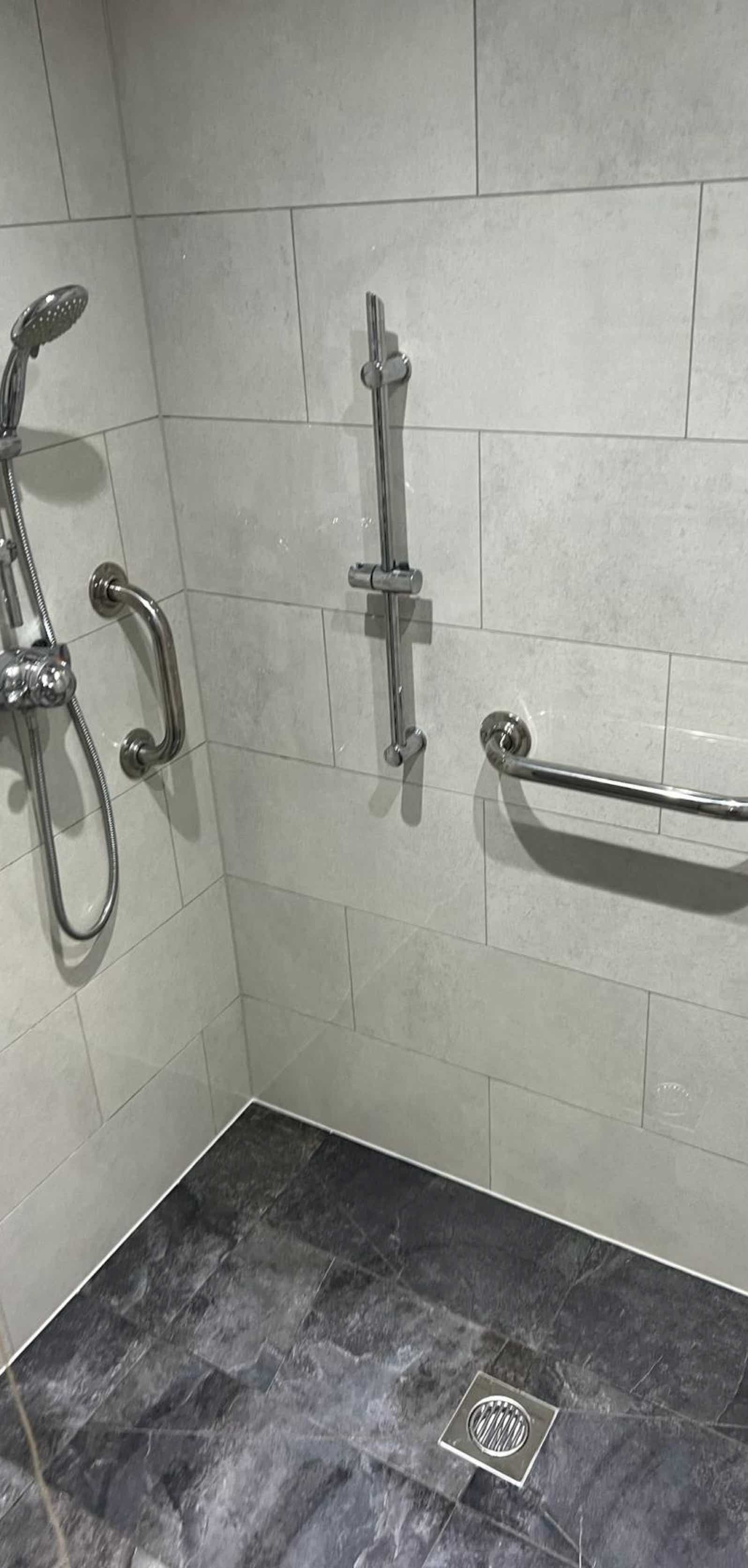 Image of wet room shower area with mobility fittings expertly installed by Plumb Yorkshire Ltd.