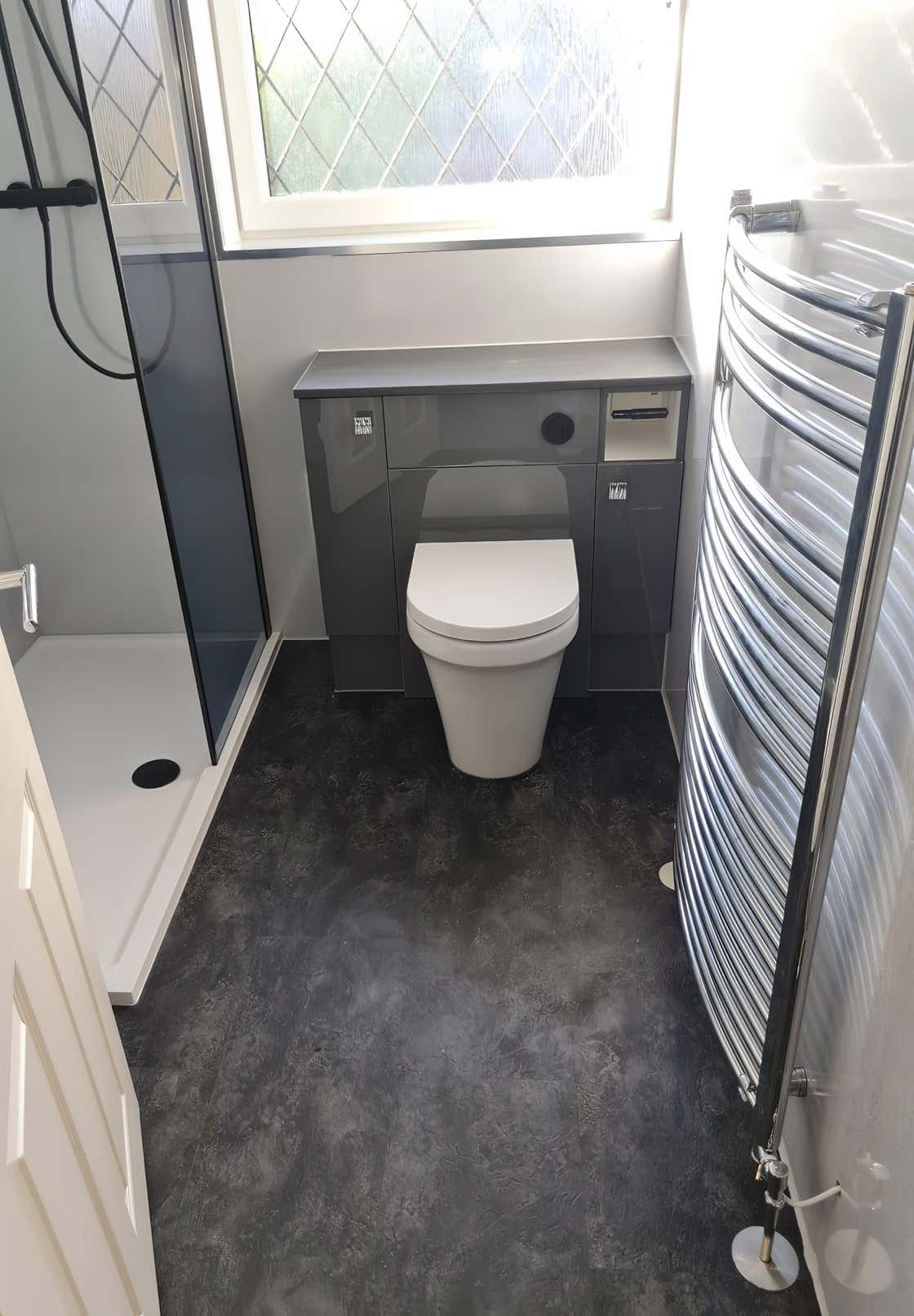 Image of a modern bathroom in grey and white with lvt flooring installed by Plumb Yorkshire Ltd.